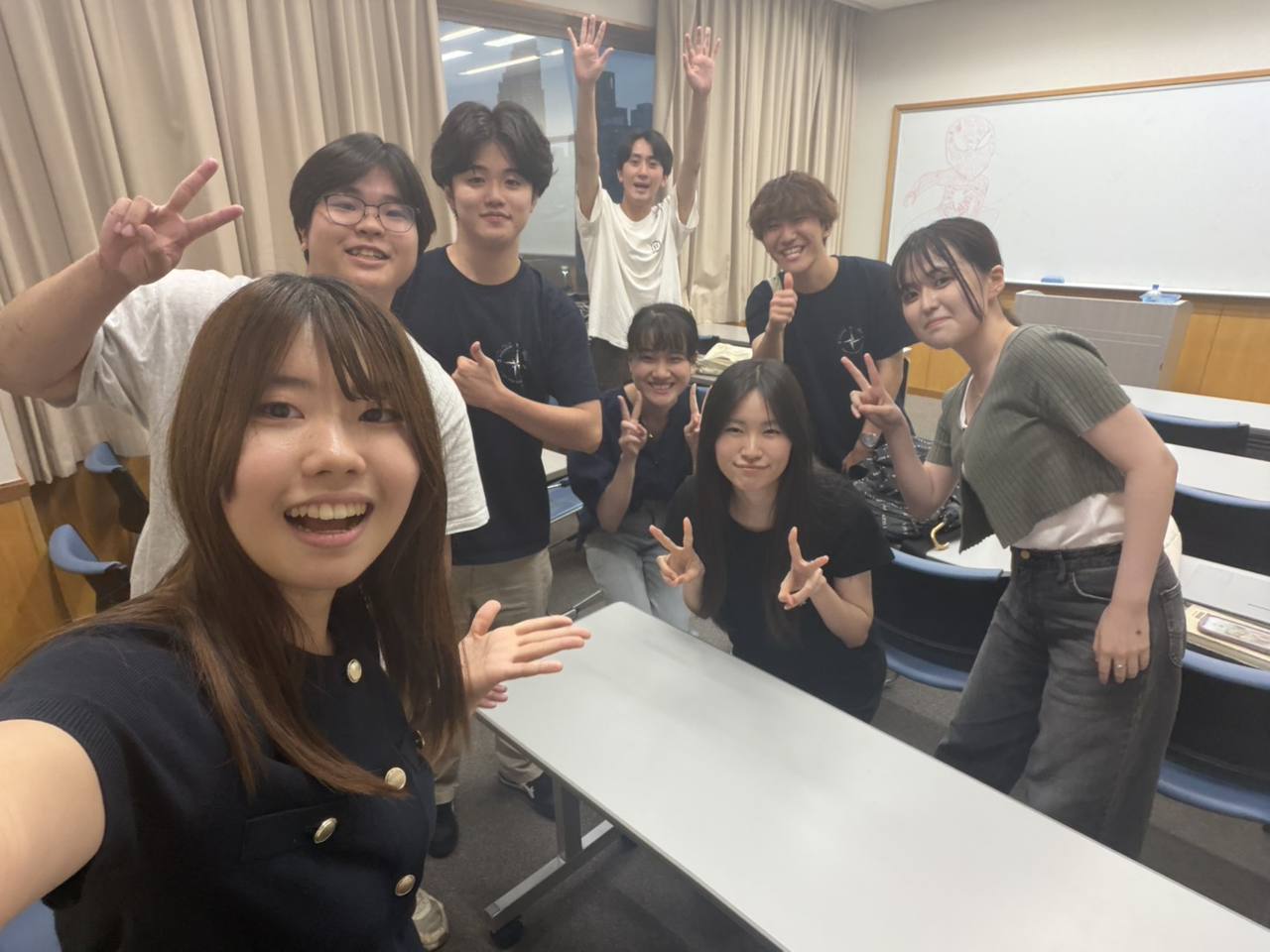 英会話部の活動後に教室で手を振るメンバーの集合写真